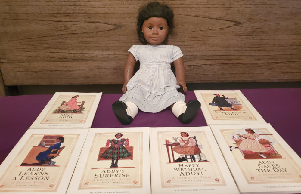 My Addy doll surrounded by the six books in her original box set.